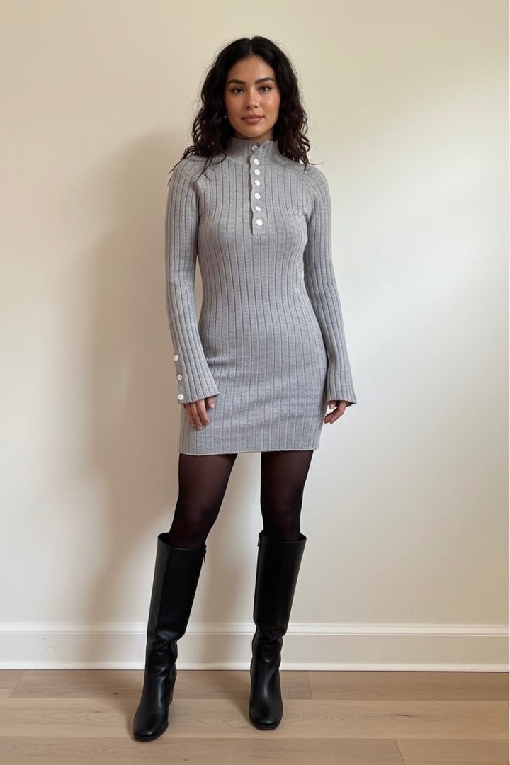 A chic grey ribbed knit mini dress featuring long sleeves, a mock neck, and elegant button details. Soft, stretchy, and perfect for fall/winter day-to-night outfits. Shop Bougieque.
