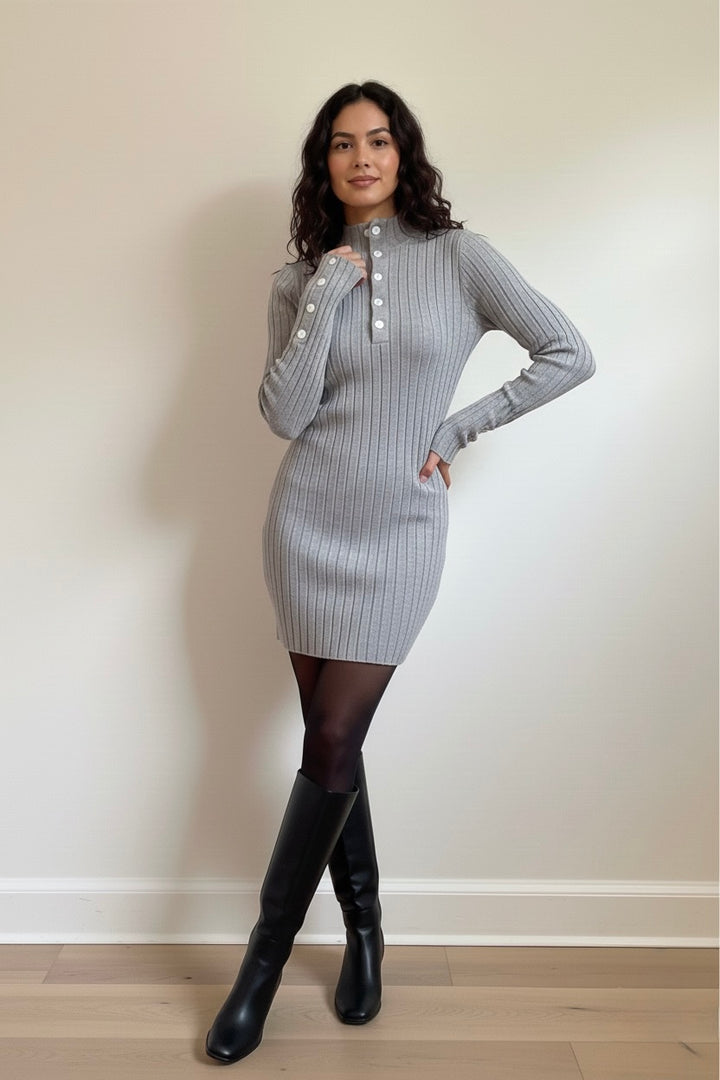 A chic grey ribbed knit mini dress featuring long sleeves, a mock neck, and elegant button details. Soft, stretchy, and perfect for fall/winter day-to-night outfits. Shop Bougieque.
