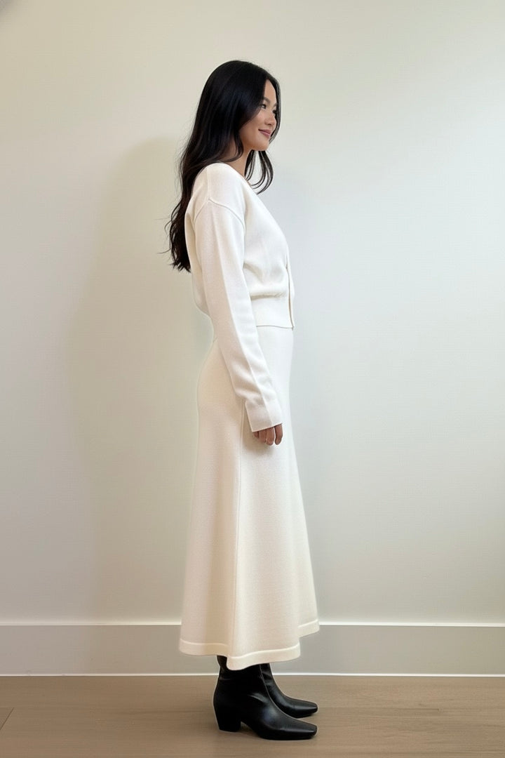 Ivory two-piece knit set featuring a cinched-waist cardigan and a flowy midi skirt. Soft, elegant, and perfect for elevated everyday style.